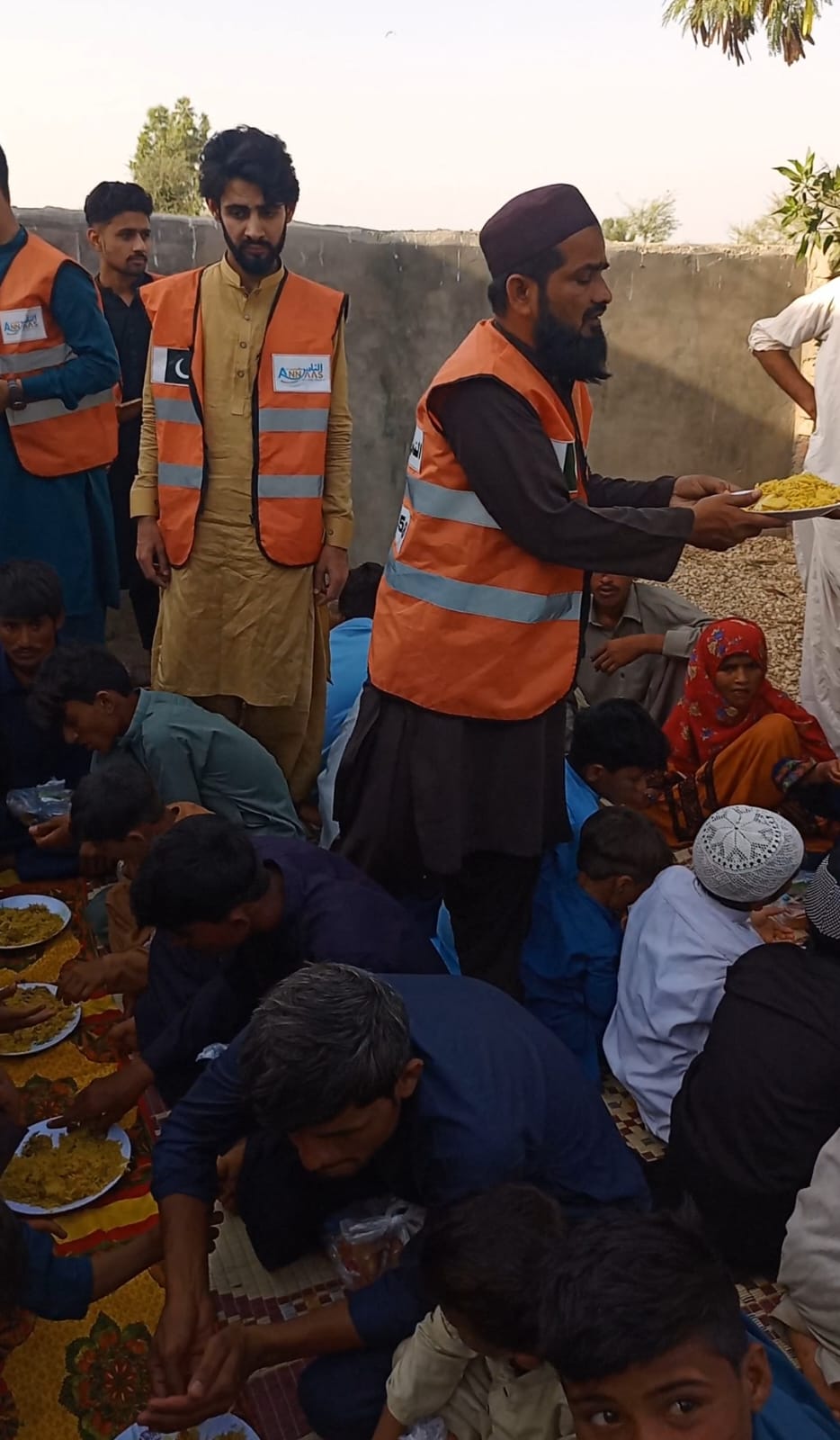Annaas Welfare Trust volunteers serving food plates to community members Sindh